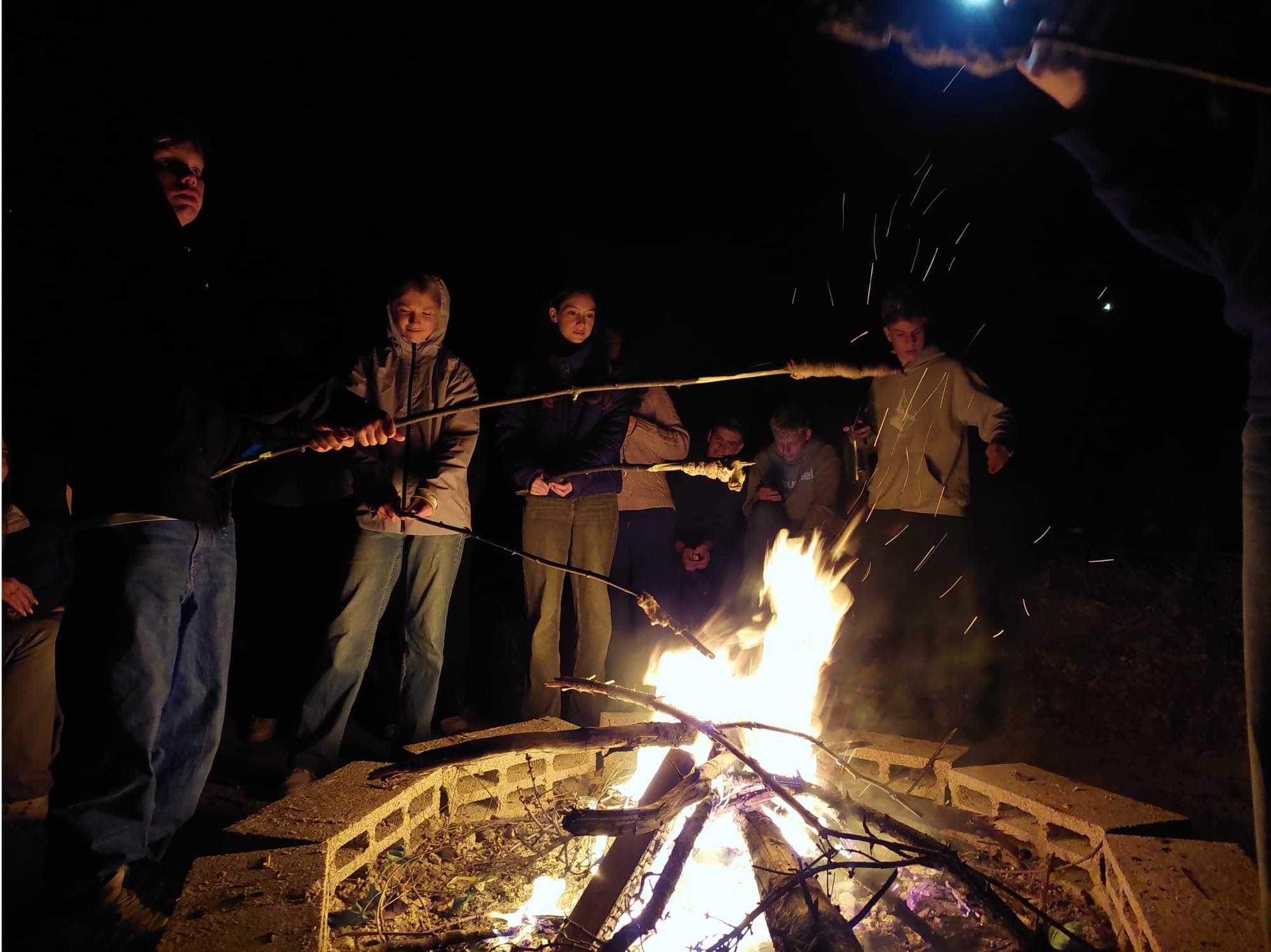Lagerfeuer mit Funkenflug am Abend